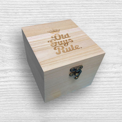 Wooden box with 'Old Guys Rule' engraving on a textured white background