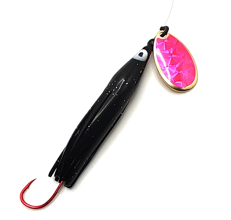 A fishing lure with a black skirted body, red hook, and a bright pink faceted metal blade with a gold border, shown on a plain white background.